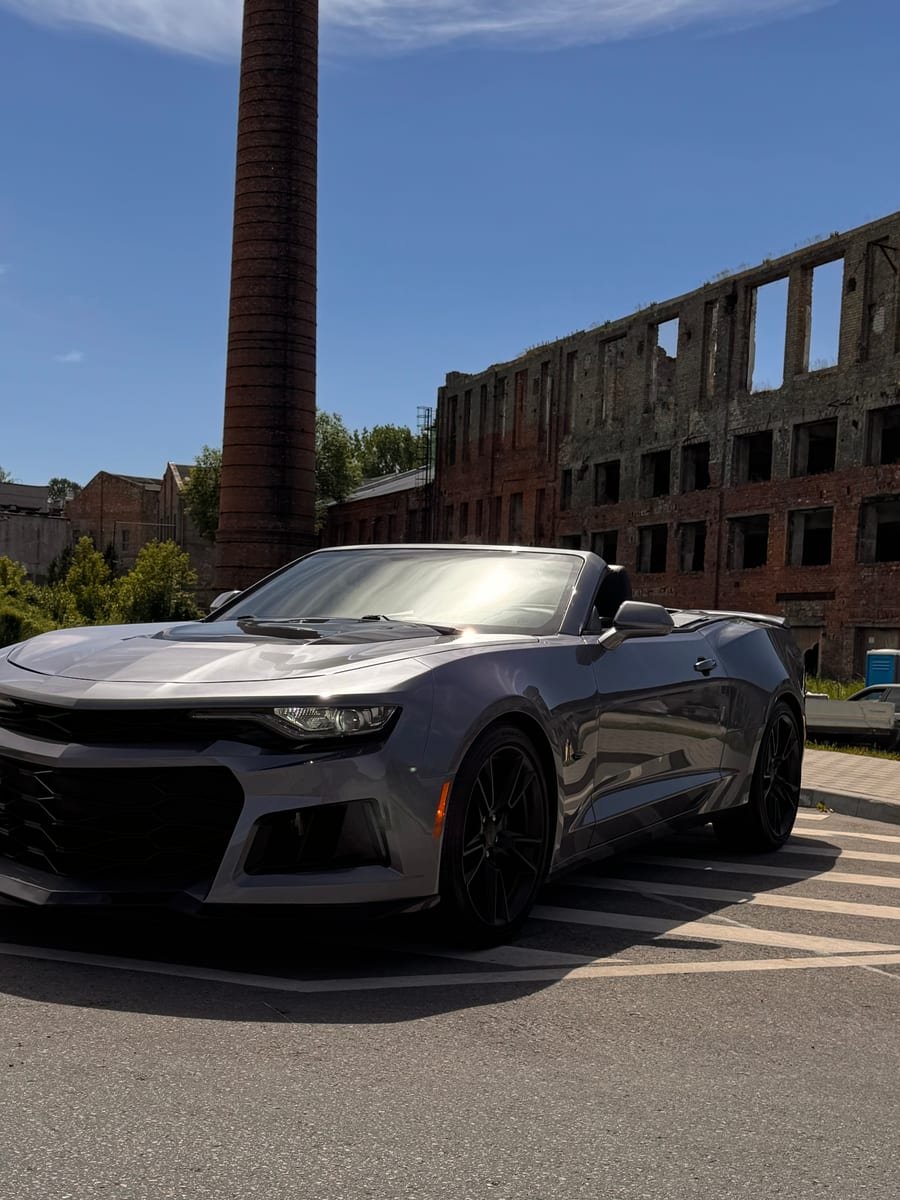 Pilkas Chevrolet Camaro kabrioletas lauke po priežiūros
