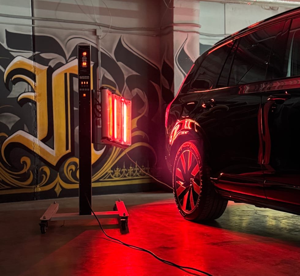 Infraraudonųjų spindulių lempa džiovina apsauginę dangą ant automobilio kėbulo